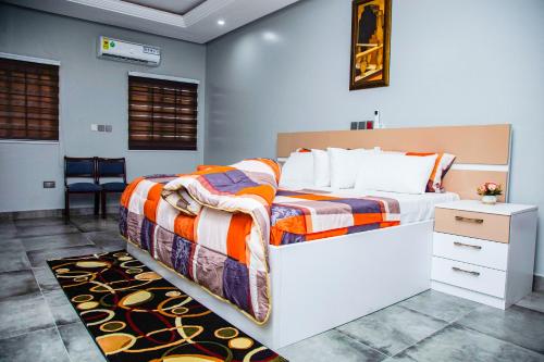 - une chambre avec un grand lit, une table de chevet et une sidx sidx dans l'établissement PEK Villa, Cozy Luxury Hideouts, 25 mins from Airport, à North Legon