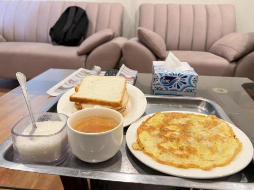 a tray with a breakfast of pancakes and coffee on a table at Secret Garden in Islamabad