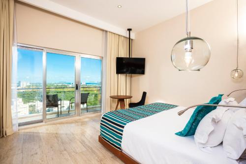 a bedroom with a bed and a large window at Krystal Urban Cancun & Beach Club in Cancún