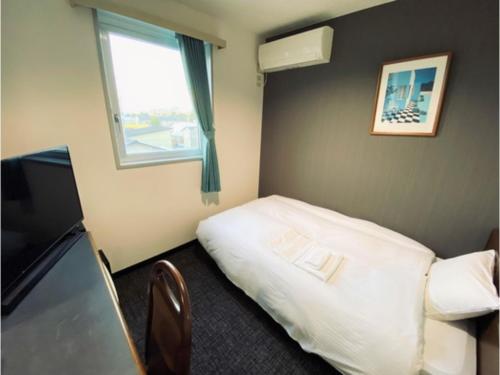 八戸市にあるHotel Tetora Honhachinohe - Vacation STAY 97875vのベッドと窓のあるホテルの部屋