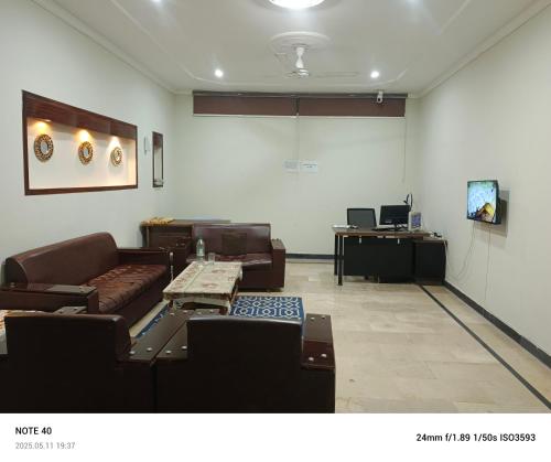 a living room with couches and a table and a screen at Secret Garden in Islamabad