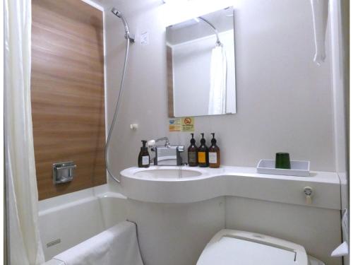 a bathroom with a sink and a toilet and a mirror at Smile Hotel Kushiro - Vacation STAY 10575v in Kushiro