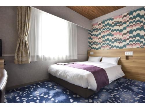 a bedroom with a bed and a large window at Smile Hotel Kushiro - Vacation STAY 10548v in Kushiro
