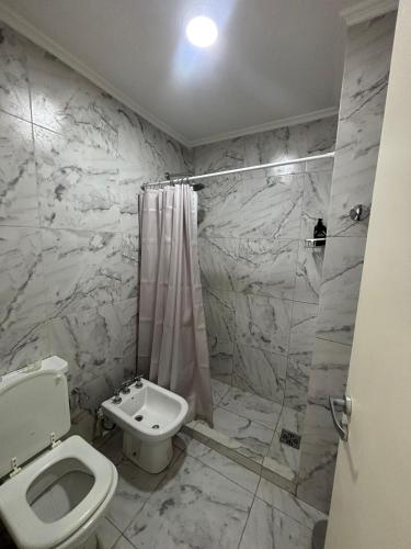 a white bathroom with a toilet and a shower at Mirador 360 in Villa María