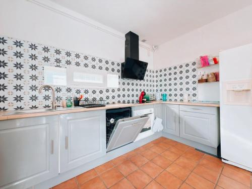 a kitchen with white cabinets and a sink at Maison familiale , piscine chauffée - Jardin - Toulouse in Cugnaux