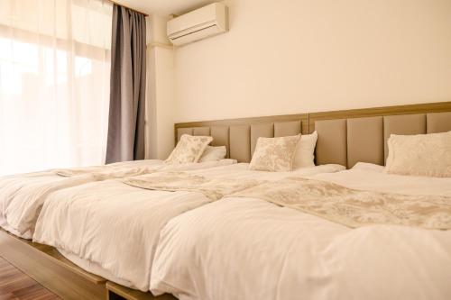 two white beds in a bedroom with a window at Minehouse Tenjinyamacho - Vacation STAY 73326v in Nagoya