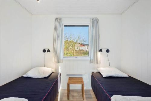 a bedroom with two beds and a window at AE238-Aeroskobing-Skraningen-1 in Ærøskøbing