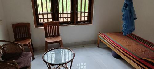 a room with a bed and chairs and a window at Sanduhan Villa in Warakapola