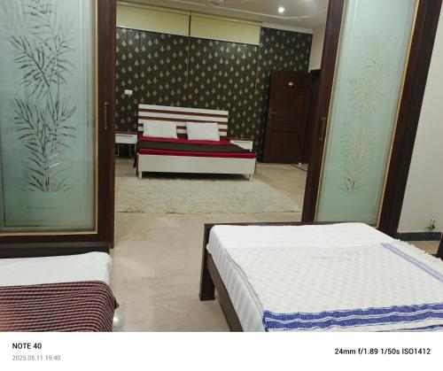 a bedroom with two beds and a couch in it at Secret Garden in Islamabad
