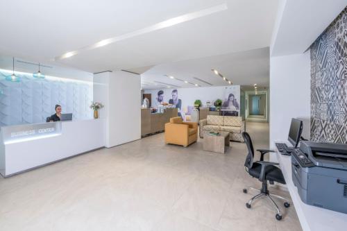an office with a reception area with a desk and chairs at Krystal Urban Cancun & Beach Club in Cancún
