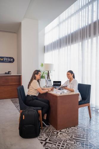 two women sitting at a desk in an office at Krystal Urban Cancun & Beach Club in Cancún