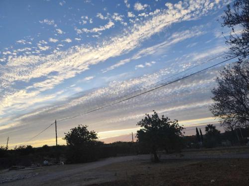 a cloudy sky with trees and a dirt road at QingQing民宿 in Moncarapacho