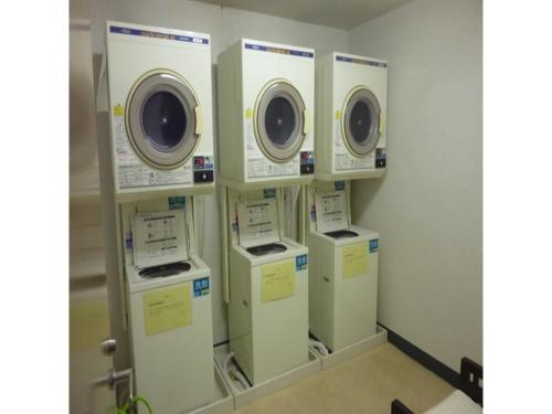 a laundry room with four washers and dryers on display at Smile Hotel Kakegawa - Vacation STAY 77614v in Kakegawa