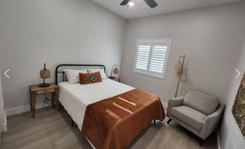 un dormitorio con una cama y una silla en River Trail Stays - Rivers Edge, en Tucson