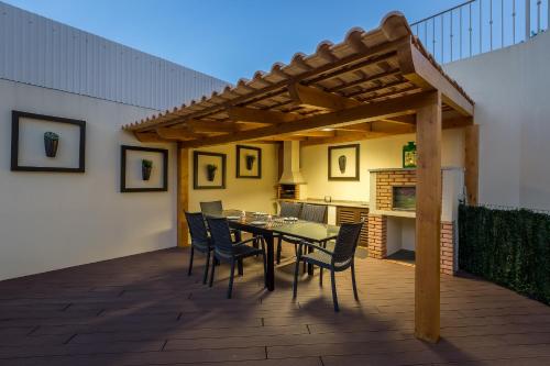 a patio with a table and chairs under a wooden pergola at D_Loft Sea and Golf in Albufeira