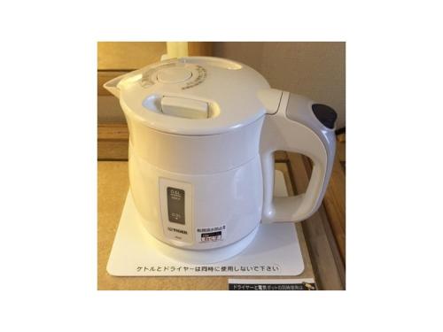 a white electric tea kettle sitting on a counter at Smile Hotel Nagoya Shinkansenguchi - Vacation STAY 05091v in Nagoya