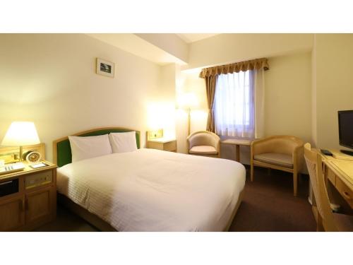 a hotel room with a white bed and a television at Smile Hotel Nagoya Shinkansenguchi - Vacation STAY 05091v in Nagoya