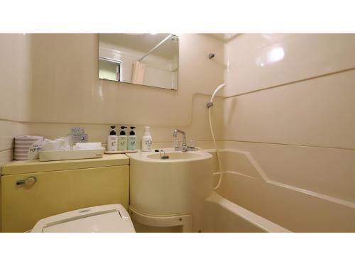 a bathroom with a sink and a toilet and a mirror at Smile Hotel Nagoya Shinkansenguchi - Vacation STAY 05091v in Nagoya