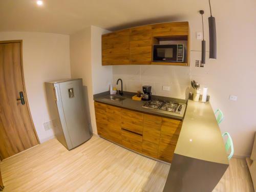a kitchen with a stainless steel refrigerator and a microwave at Santorini Apartamentos Amoblados in Pereira