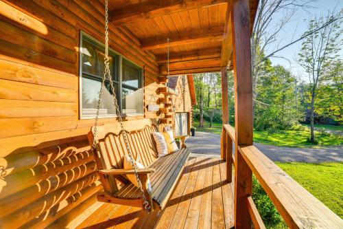 a porch of a wooden cabin with a swing at West Branch Delaware River Cozy Cabin Retreat! in Deposit