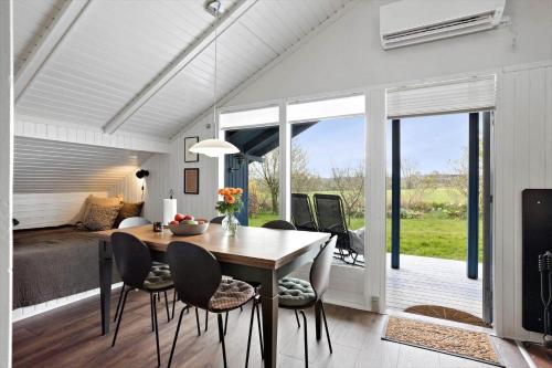 a dining room with a table and chairs and a bedroom at AE311-Aeroskobing-Hanses-Ager-11 in Ærøskøbing