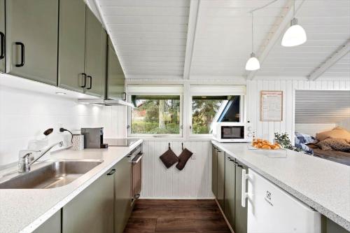 a kitchen with white counters and a sink and a window at AE311-Aeroskobing-Hanses-Ager-11 in Ærøskøbing