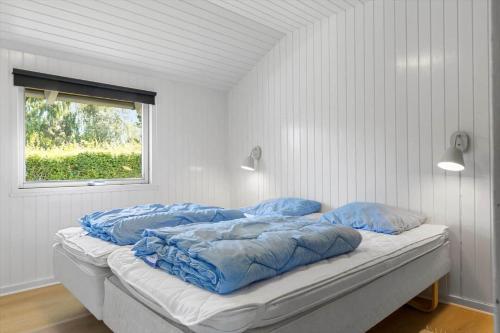a bed with blue pillows on it in a room at SB102-Sydals-Laerkemose-18 in Neder Lysabild