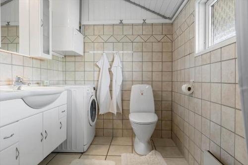 a white bathroom with a toilet and a sink at SB102-Sydals-Laerkemose-18 in Neder Lysabild