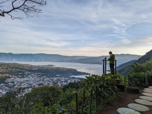 a man standing on top of a hill overlooking a city at Hotel Toliman in San Lucas Tolimán