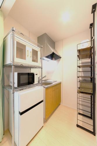 a kitchen with white appliances and wooden cabinets at Trailer Ship Garden Aso - Vacation STAY 09150v in Aso
