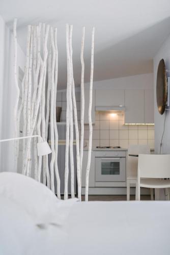 a white kitchen with white branches on the wall at Quinta Do Miguel in Aldeia do Meco