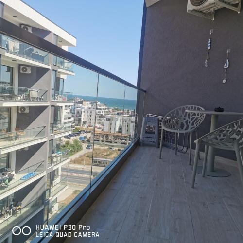 a balcony with a table and a view of the ocean at Meraki Resort & Spa Isabellae Home in Mamaia Nord