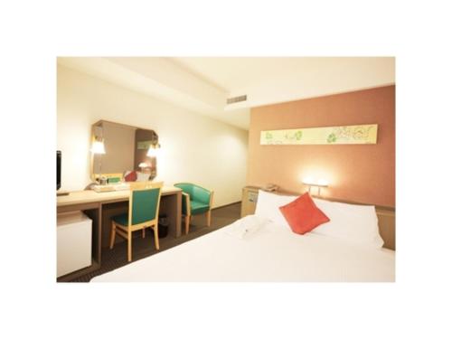 a bedroom with a bed and a desk and a mirror at Smile Hotel Naha City Resort - Vacation STAY 05994v in Naha