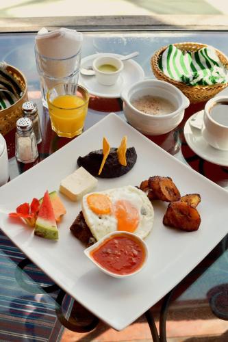 a plate of food with eggs and fruit on a table at Hotel Toliman in San Lucas Tolimán