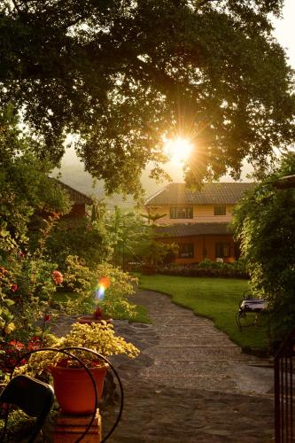 a pathway leading to a house with the sun shining at Hotel Toliman in San Lucas Tolimán