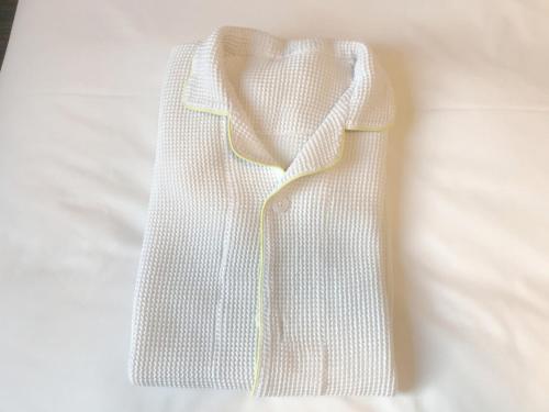 a white shirt is sitting on a bed at Smile Hotel Mito - Vacation STAY 99817v in Mito