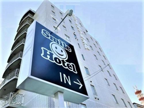 a sign in front of a tall building at Smile Hotel Mito - Vacation STAY 99817v in Mito