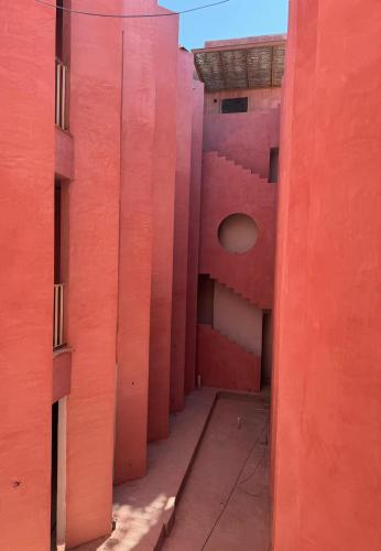 an empty hallway of a building with red walls at Laiva Hotel San Jose by Tasman in San José del Cabo