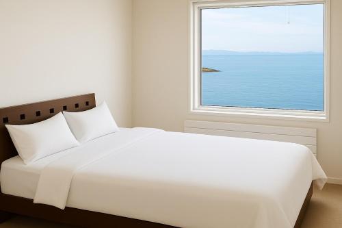 a bedroom with a large white bed and a window at Abutagun - House - Vacation STAY 98370v in Usu