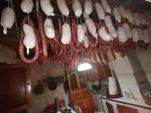 a bunch of meat hanging from the ceiling of a kitchen at Colliano Hotel in Colliano
