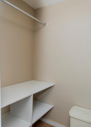 a white closet with white shelves and a toilet at Bienvenue chez nous in Otavalo