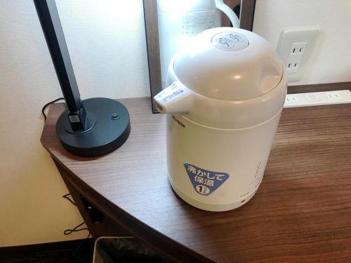 a plastic cup sitting on a desk next to a lamp at Smile Hotel Mito - Vacation STAY 99827v in Mito