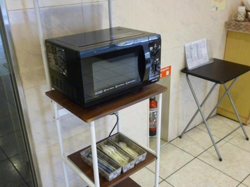 a microwave oven on a stand in a kitchen at Smile Hotel Mito - Vacation STAY 99827v in Mito
