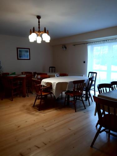 a dining room with a white table and chairs at EkoTurystyka Natura Gwiazd - Green Velo - Workation Park - Ziołowy Klimat Bieszczad in Dubiecko