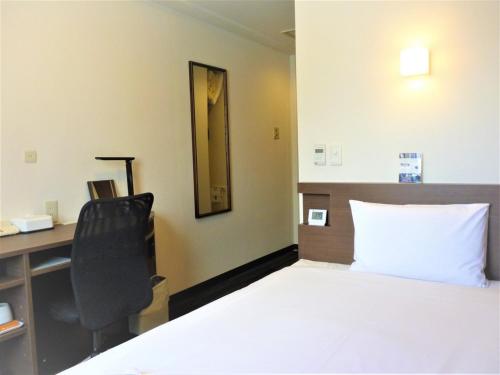 a bedroom with a bed and a desk and a chair at Smile Hotel Mito - Vacation STAY 99832v in Mito