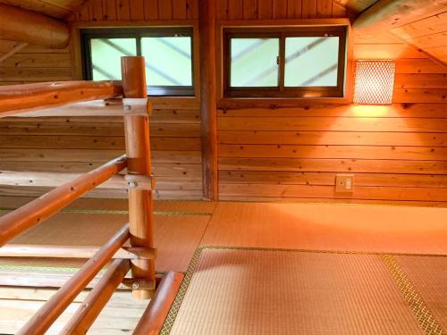 une pièce vide dans une cabane en bois avec des fenêtres dans l'établissement Washiki Shiki no Sato Cottage - Vacation STAY 03120v, à Wajiki