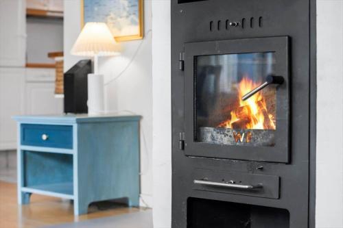 a fireplace with a fire in it next to a table at SB109-Aabenraa-Golfsvinget-40 in Aabenraa