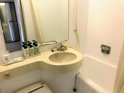 a bathroom with a sink and a toilet and a mirror at Smile Hotel Mito - Vacation STAY 99814v in Mito