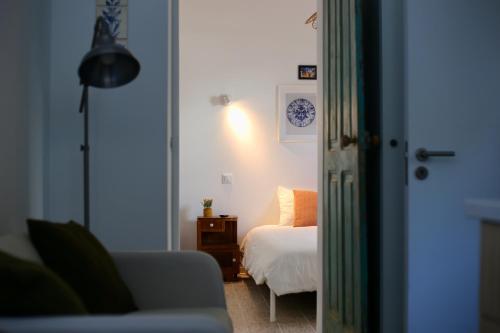 Un dormitorio con una cama y una mesa con una lámpara. en Refúgio com Jardim no Coração de Aveiro, en Aveiro
