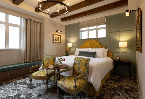 a bedroom with a bed and two chairs and a table at Rosemead House in Victoria